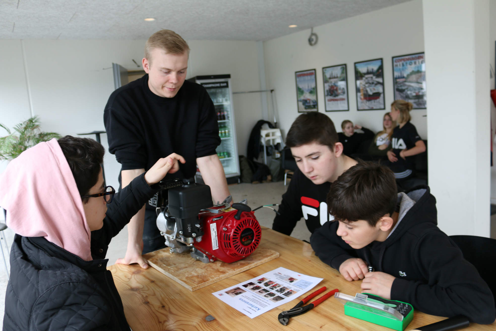 Karam, Jeppe og Arian fra 8.D øver sig i at samle en gokartmotor under kyndig vejledning af Tobias Thrane, der læser til automatiktekniker.